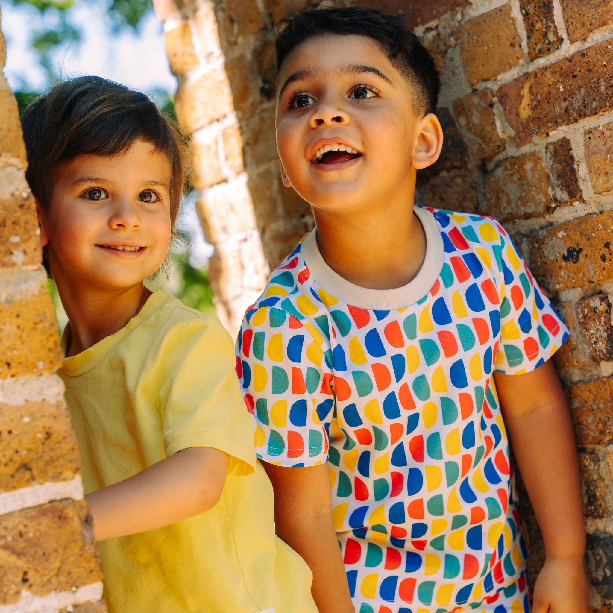 Boy and girl wearing bright sun protective clothes and smiling standing together