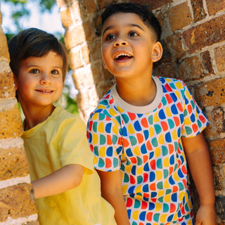 Boy and girl wearing bright sun protective clothes and smiling standing together