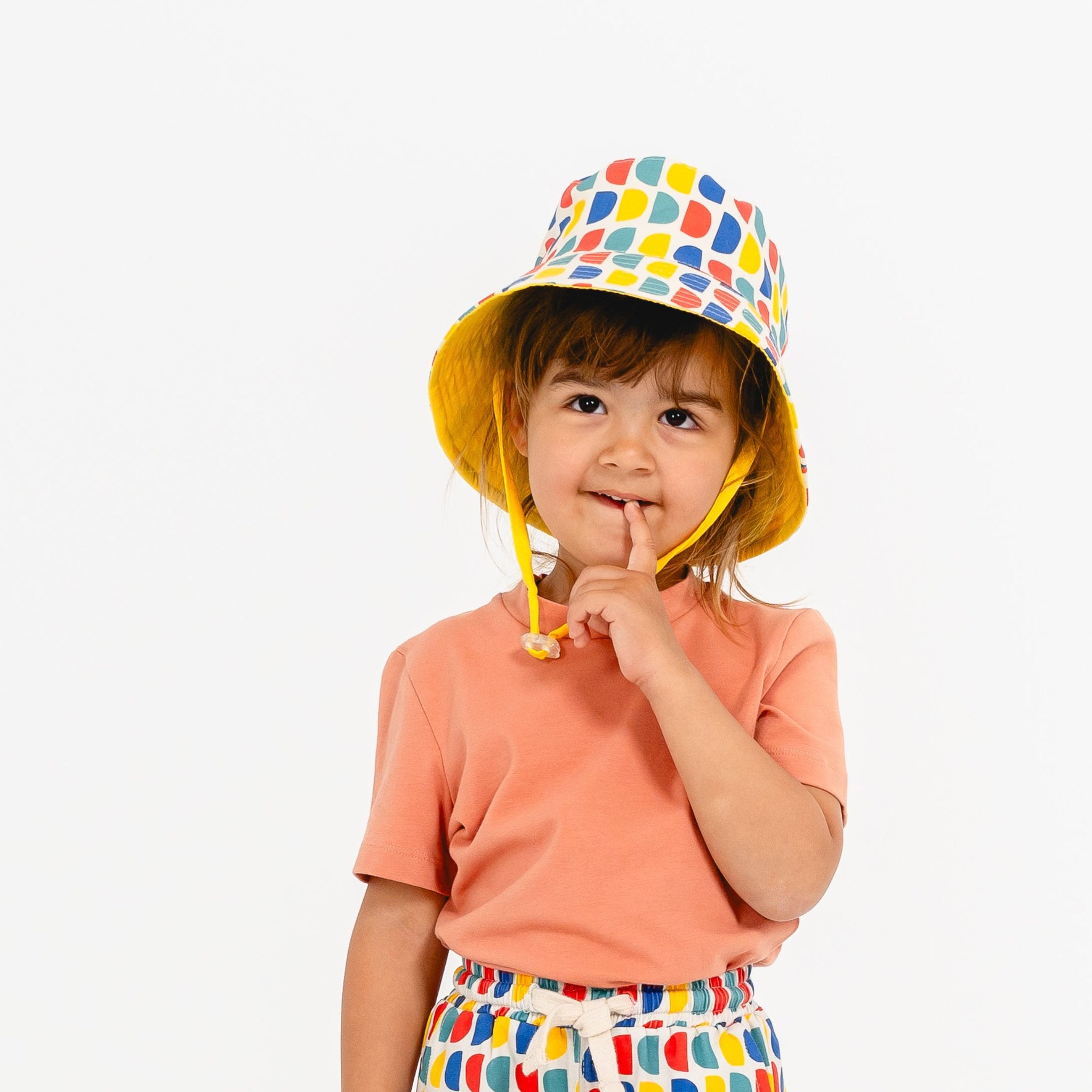 Toddler wearing apricot summer t-shirt by SunKin and d-print hat and matching shorts
