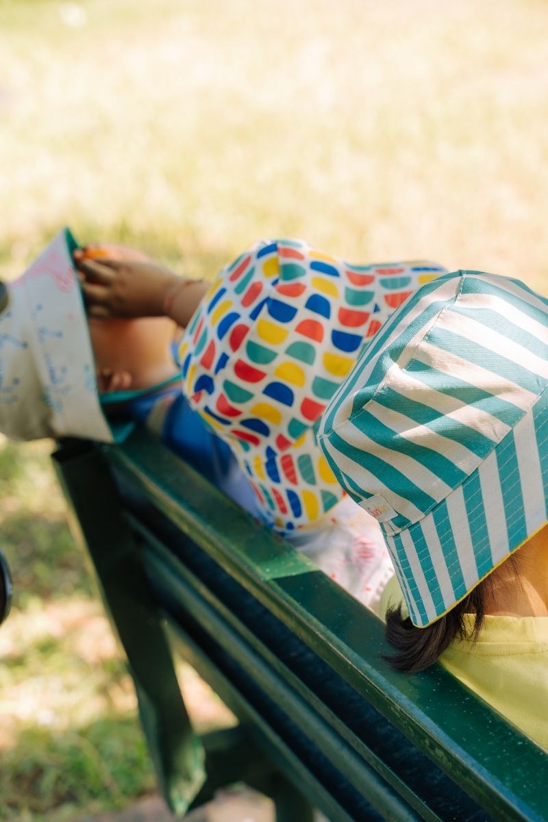 Kids on bench wearing bright SunKin sun-safe hats