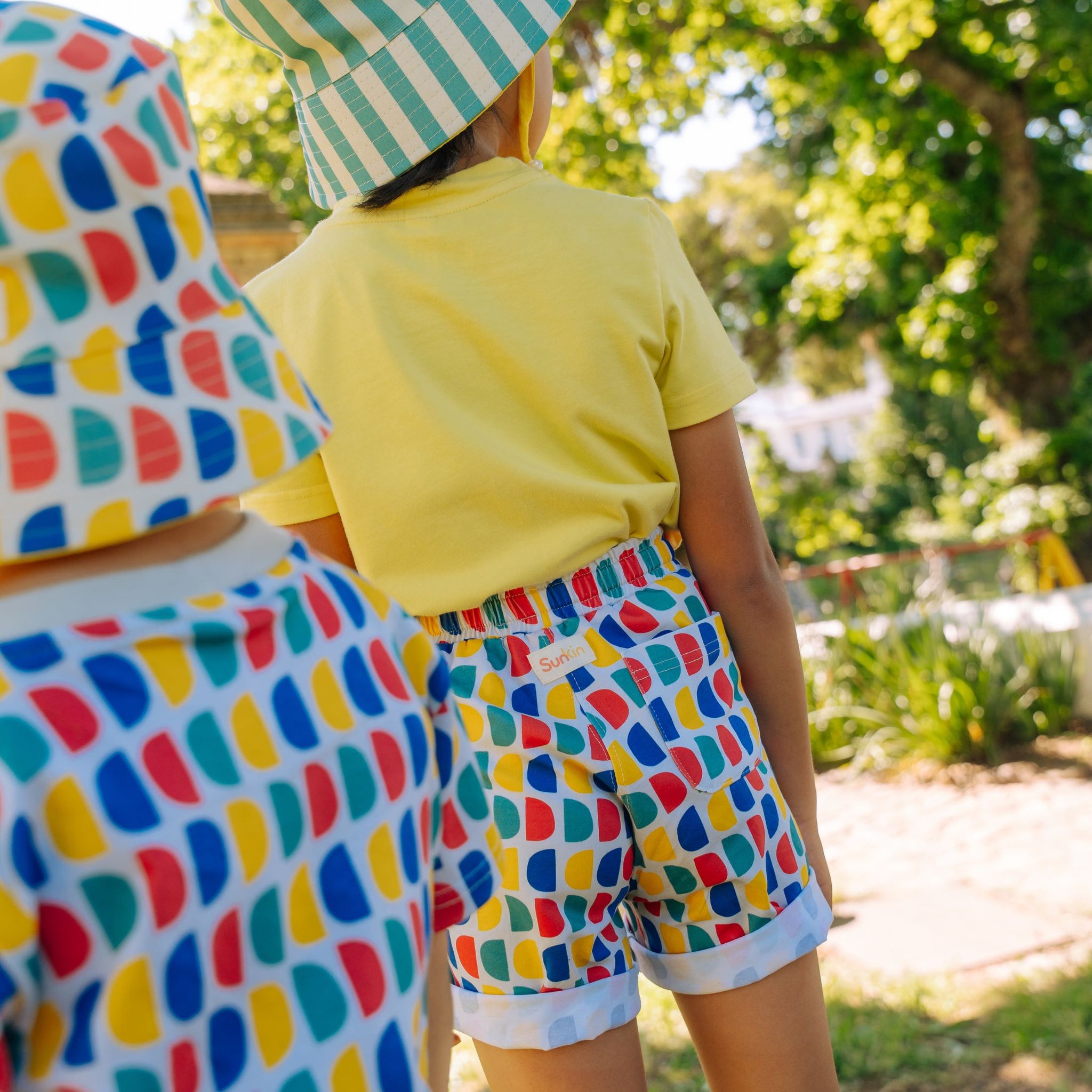 child wearing Sunkin UV protective shorts in D print back view