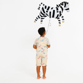 Back view of child holding a zebra balloon wearing zebra print shortarees by SunKin