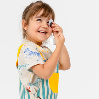 Girl girl wearing playing with a goggly eye and giggling wearing SunKin summer outfit