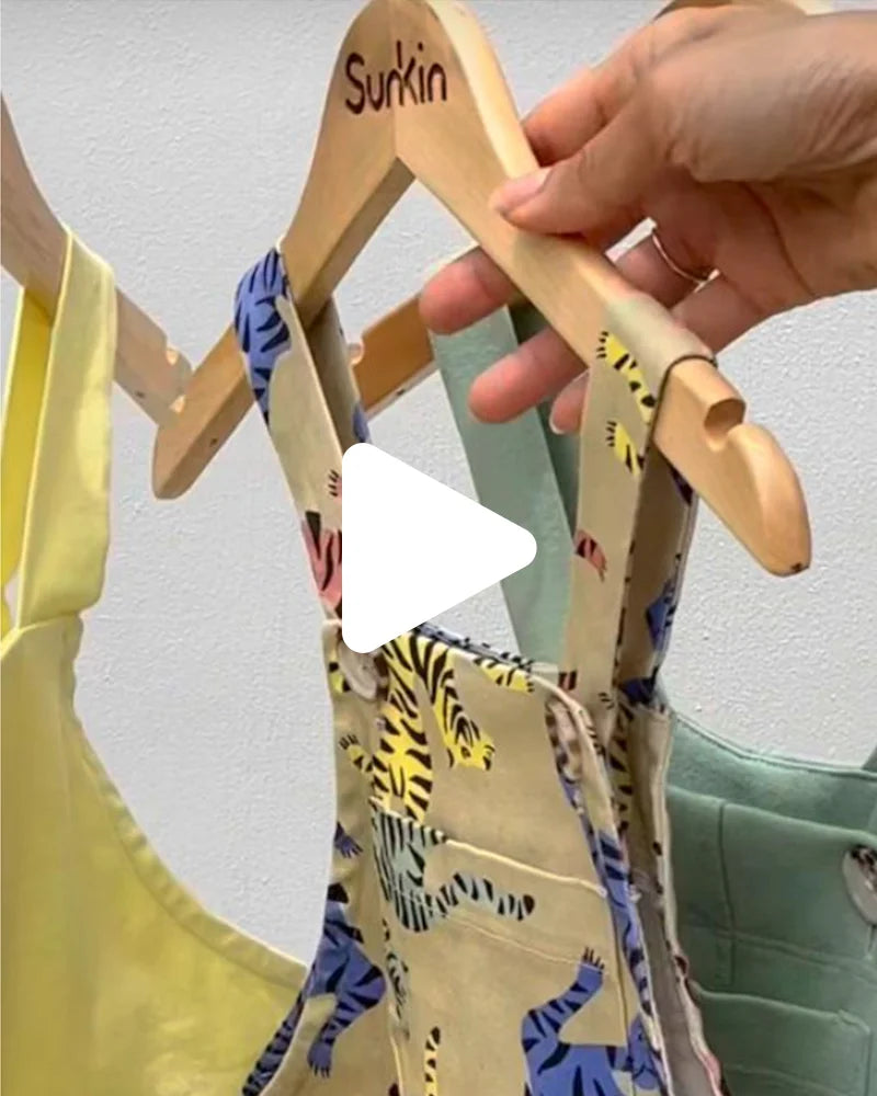 Dee from SunKin holding up tiger-print dungarees in a video explaining the smart sun-safe design