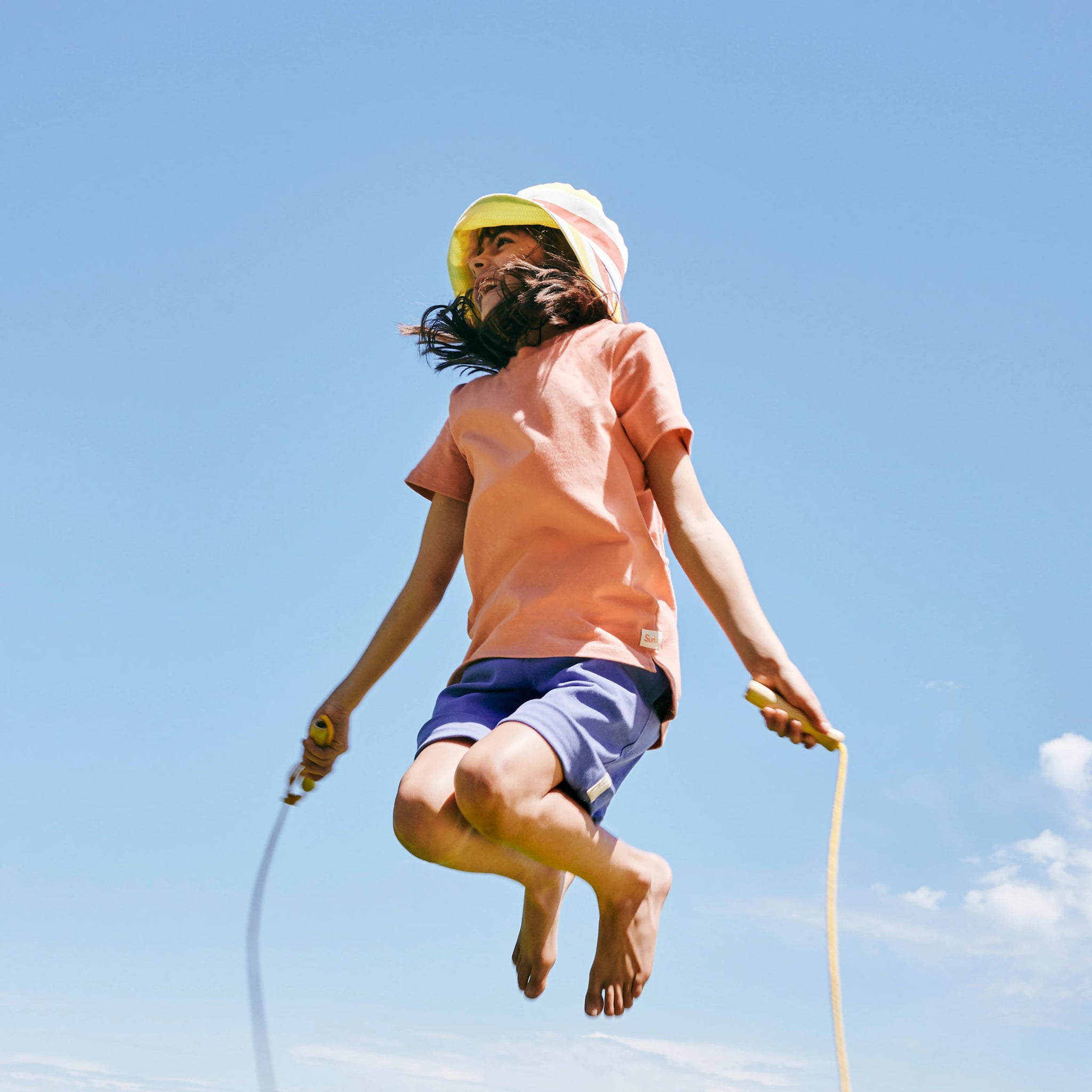 Child skipping in SunKin’s Apricot UPF50+ cotton t-shirt—sun-safe, breathable, and made for joyful movement.