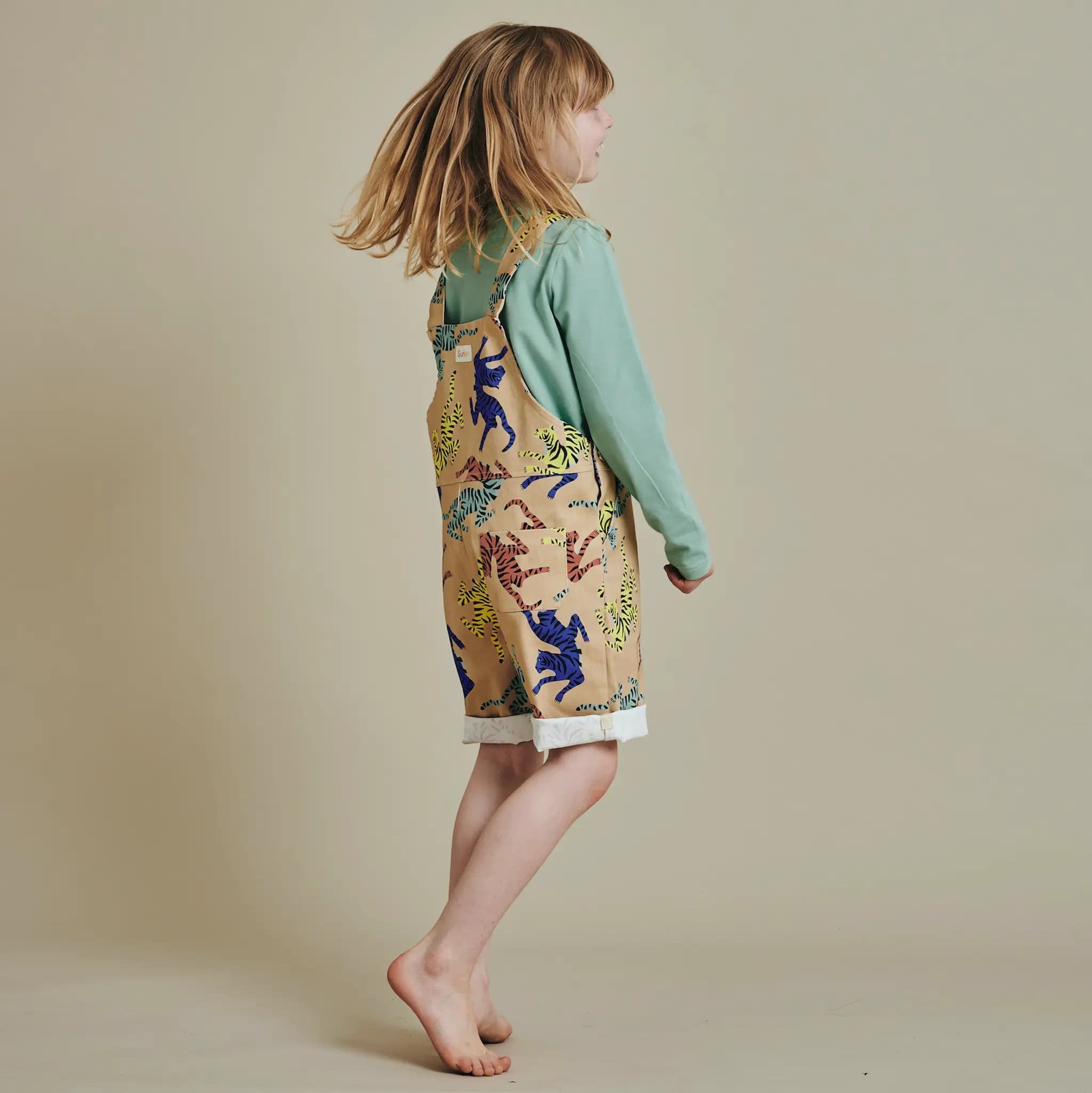 Child in SunKin’s UPF50+ Tiger Print Shortaree and green long sleeve tee—playful and sun-safe style for everyday outdoor adventures.