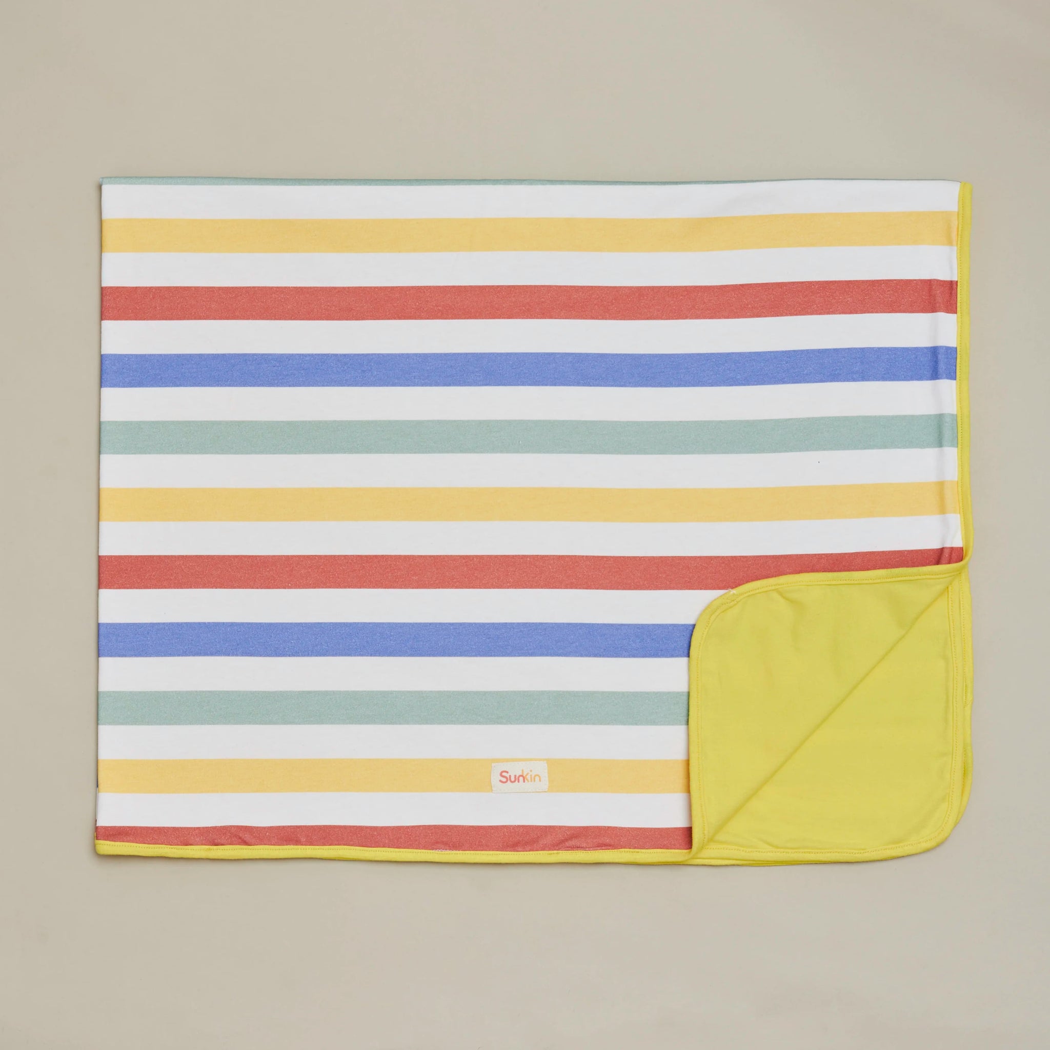 Child wrapped in SunKin’s sun-safe reversible blanket—ideal for stroller naps, beach breaks, and outdoor adventures